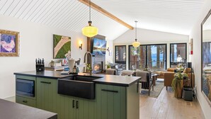 A modern kitchen with a large island, built-in appliances, and a dining area with a view.