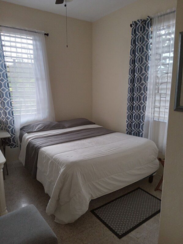 A bedroom with a bed, a desk, and a chair. - Enjoy Beverly Hills, Kingston, Jamaica, 4 bdrms, AC, WiFi, Spacious, Quiet, Safe (Kingston)