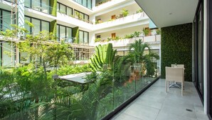 A multi-level atrium with lush greenery, glass railings, and modern architecture. - Lovely One Bedroom With Amazing Terrace View!! (Playa del Carmen)