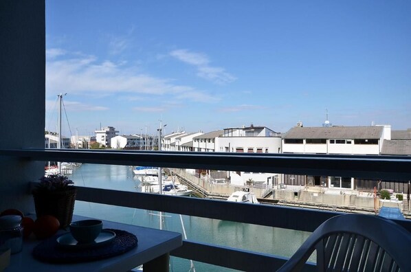A balcony with a view of a marina, including boats and buildings.