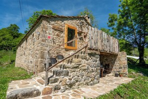 A rustic stone building with a wooden staircase leading to a door marked "LO LUCAS". - Cosy cottage in Los Valles Pasiegos, Cantabria: Lo Lucas 1920 (San Roque de Riomiera)