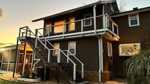 A two-story house with a balcony, a staircase, and a large window.