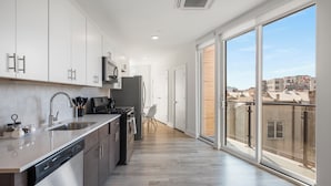 Une cuisine moderne équipée d’un lave-vaisselle, d’une cuisinière et d’un four à micro-ondes.