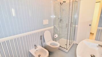 Regadera, secadora de cabello, bidet, toallas