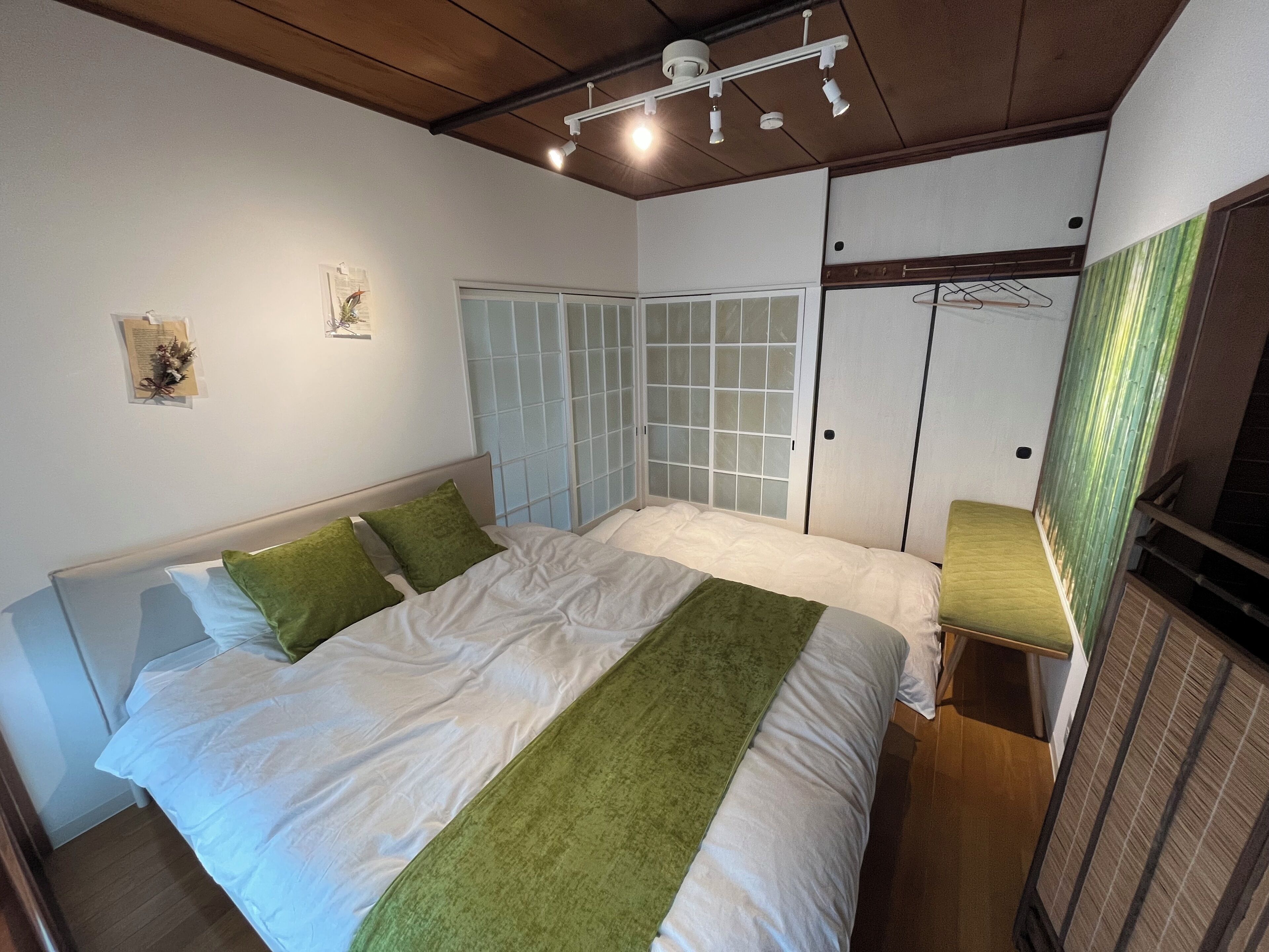 A bedroom with a bed, a wardrobe, and a window with frosted glass.