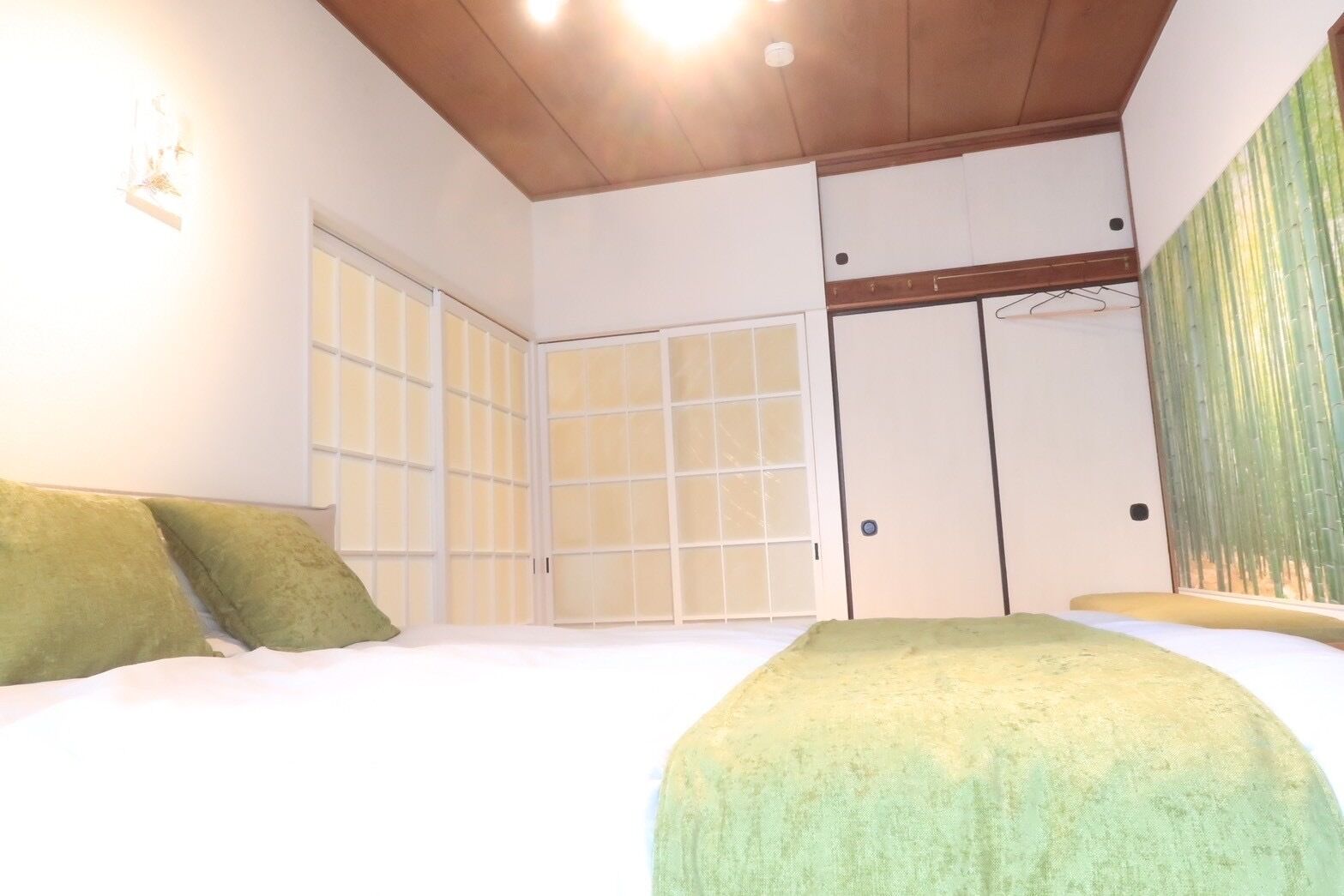 A bedroom with a bed, a wardrobe, and a sliding door.