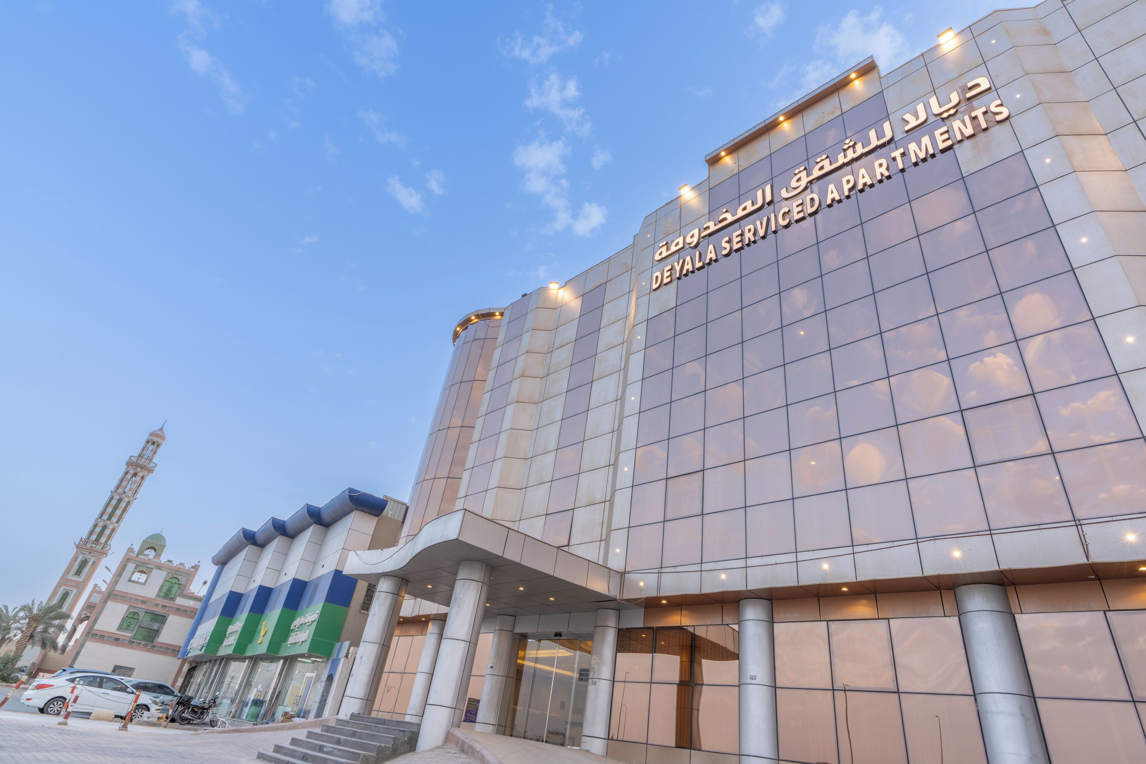 A modern building with a sign reading "DeYala Serviced Apartments".