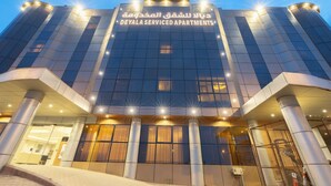 A modern building with a glass facade and illuminated signage for DEYALA SERVICED APARTMENTS. - Deyala Serviced Apartments 4 (Riyadh)
