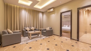 A modern hotel room with a sofa set, a small table, and a bed. - Deyala Serviced Apartments 4 (Riyadh)