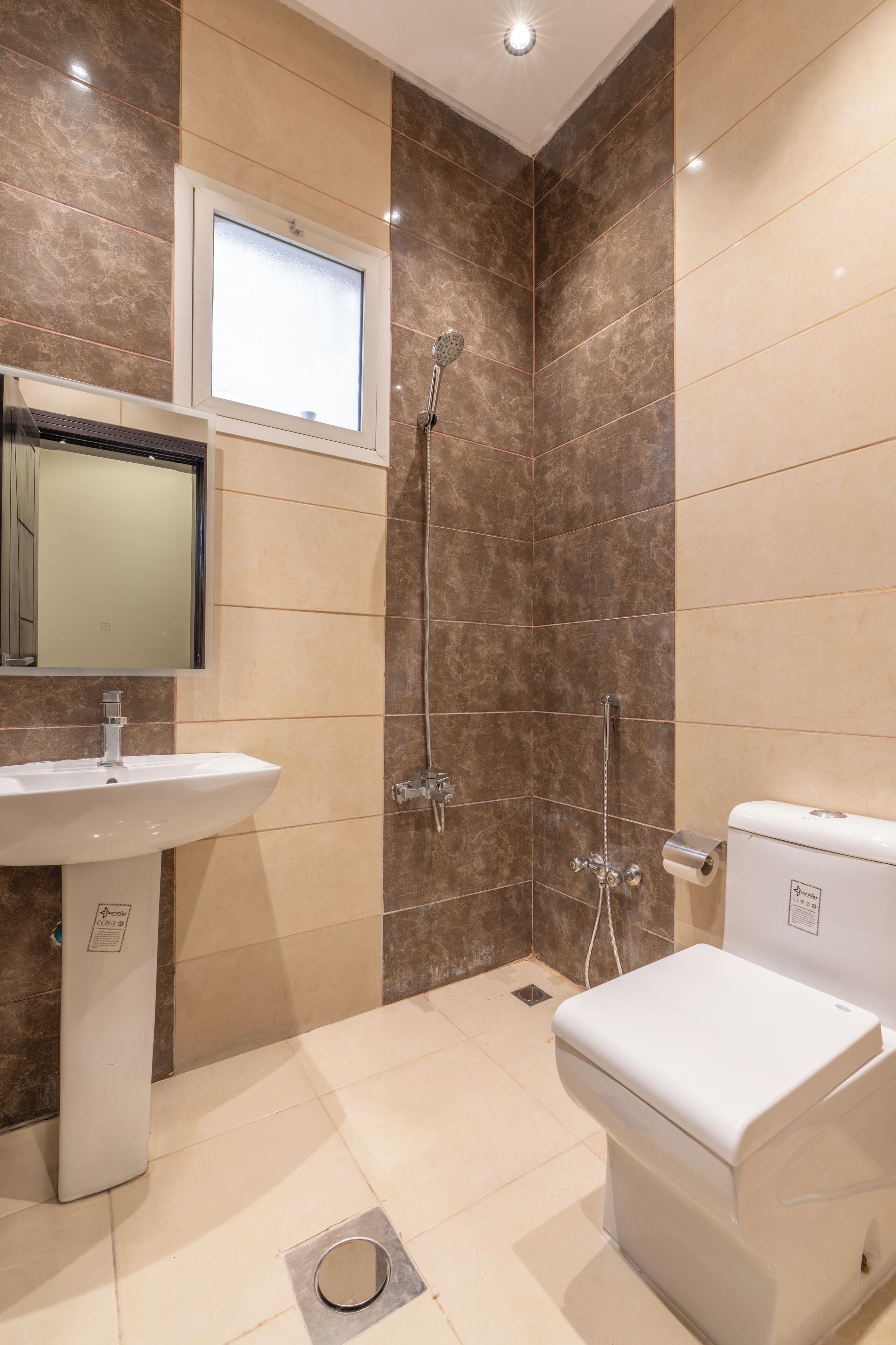 Une salle de bain moderne équipée d’un lavabo, de toilettes et d’une douche.