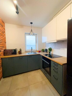 Apartamento Confort, balcón, vistas a la ciudad | Cocina privada | Hervidor eléctrico, papel de cocina y mesa de comedor