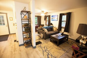 A cozy living room with a sofa, coffee table, and a bookshelf.
