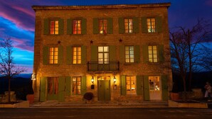 A stone building with green shutters, a balcony, and a star on the facade. - Chambres d'hôtes La Gourguille (Barjac)