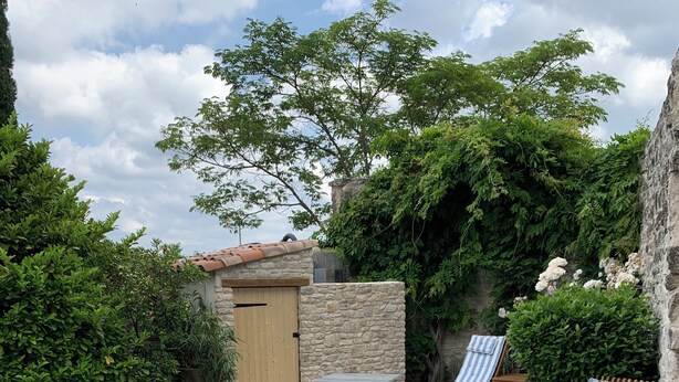 A swimming pool with a stone border and lounge chairs with striped cushions. - Chambres d'hôtes La Gourguille (Barjac)