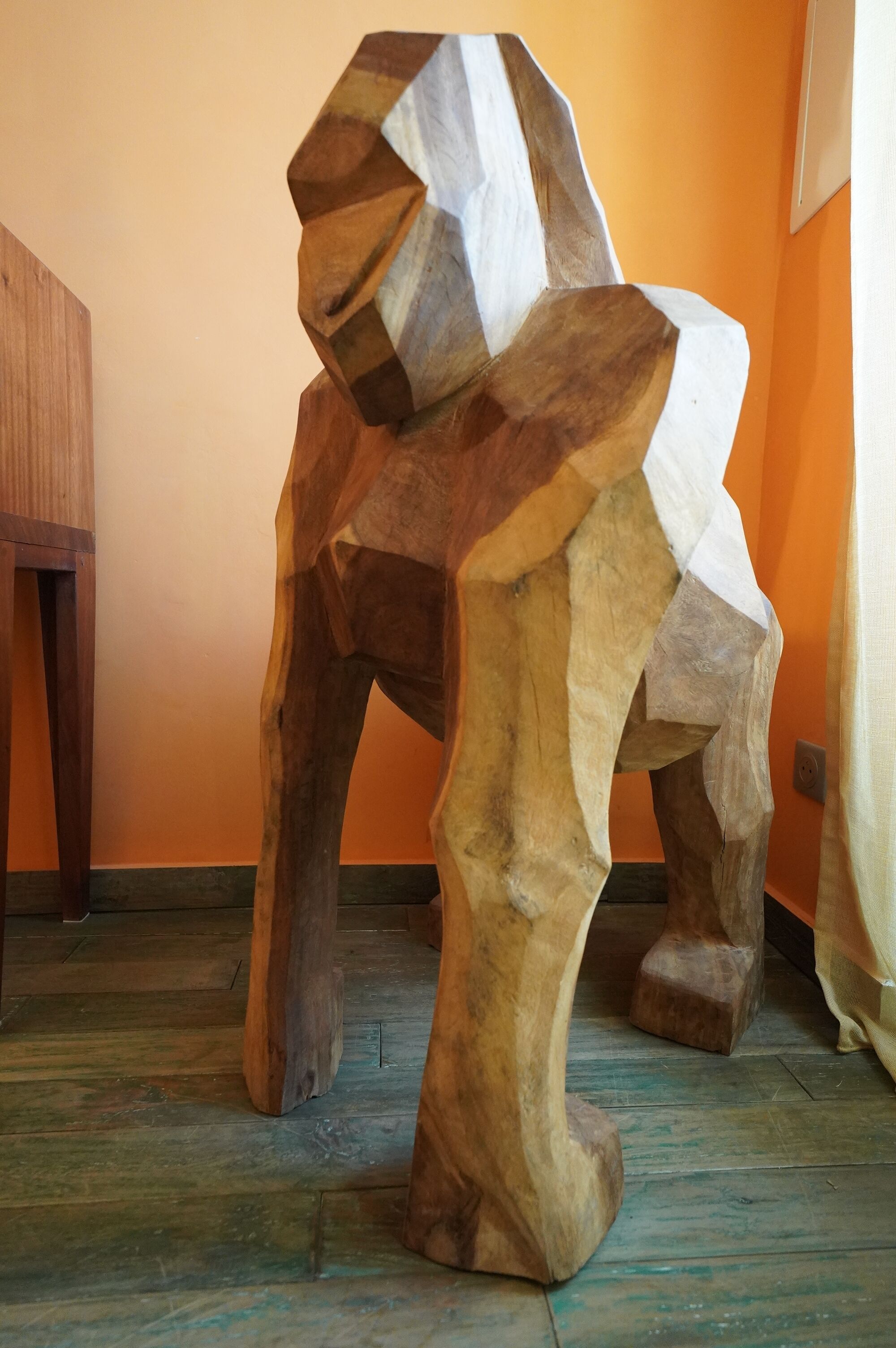 Une sculpture en bois aux formes géométriques et à la surface texturée.