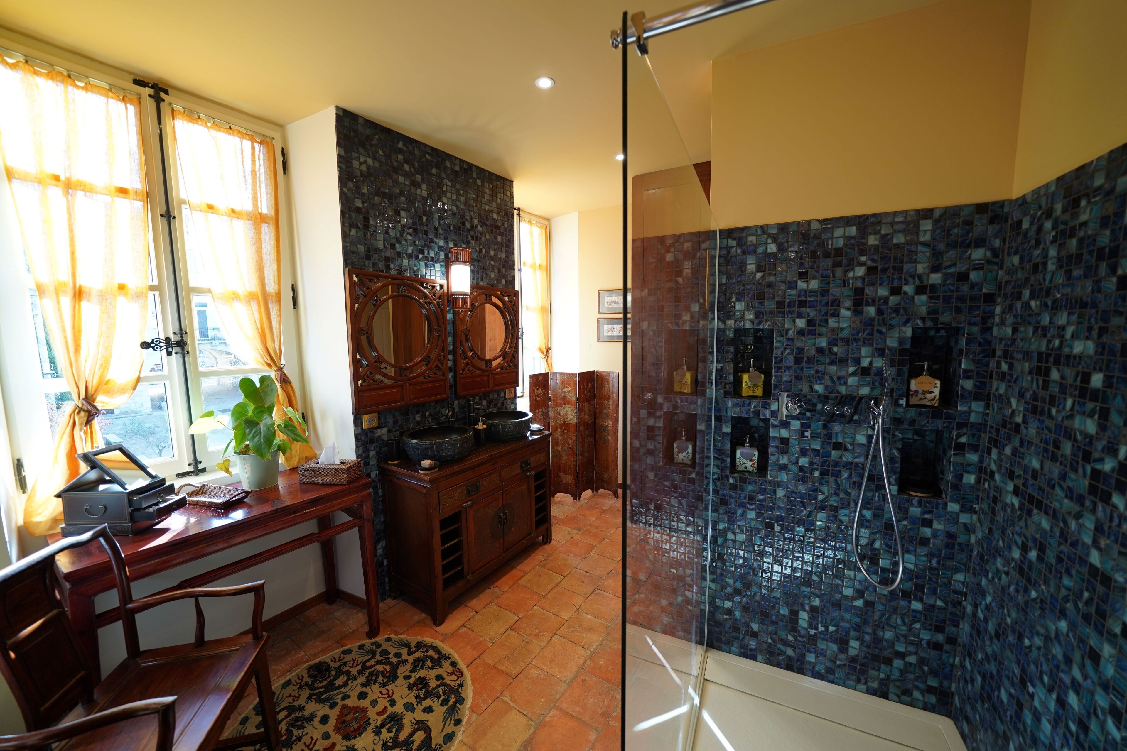 Ein Badezimmer mit Duschkabine, Waschbecken mit Spiegel und Holzschrank.