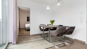 Una habitación moderna y minimalista con una mesa de comedor, sillas y un jarrón con flores.