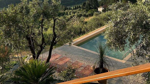 A pool with a wooden deck, surrounded by greenery and overlooking a cityscape. - Wonderful private villa for 9 guests with WIFI, A/C, private pool, TV and balcony (Montecatini Terme)