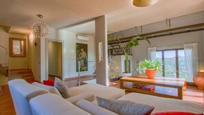 A modern living room with a large sofa, a coffee table, and a view of the outdoors. - Wonderful private villa for 9 guests with WIFI, A/C, private pool, TV and balcony (Montecatini Terme)