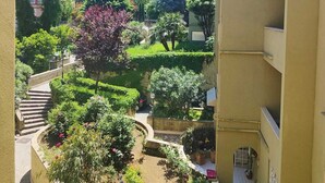 Un cortile con vista sulle montagne, immerso nel verde e con una scala che conduce a un edificio.