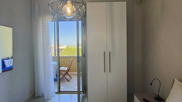 Una camera da letto con un letto, un lampadario, un armadio e un condizionatore d'aria.