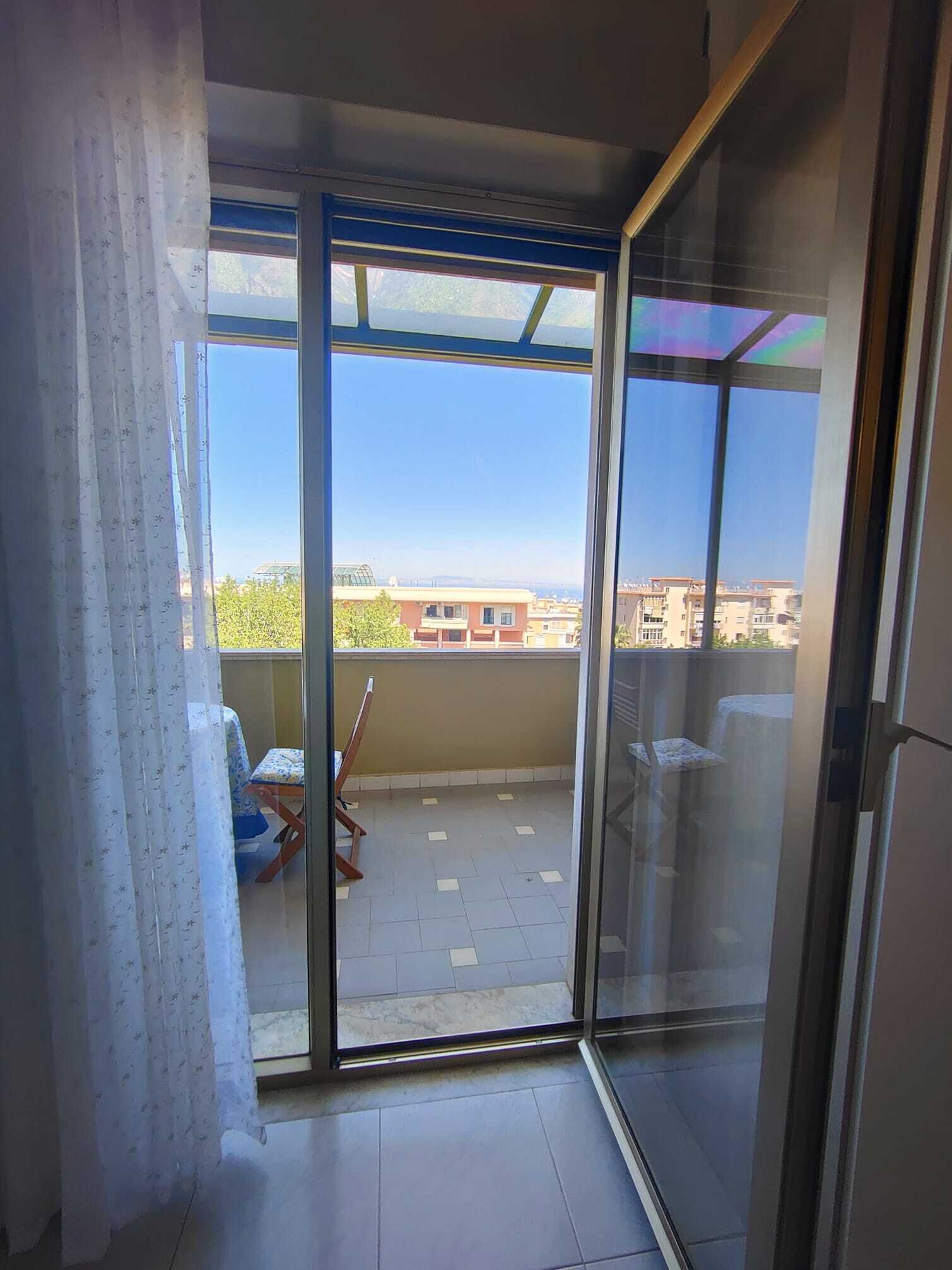 A balcony with a view of buildings and a clear sky.