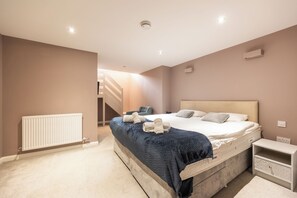 Un dormitorio con cama, mesita de noche y radiador.