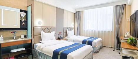 Habitación de hotel con dos camas, un escritorio, una silla, un espejo y un ventanal con cortinas.