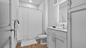 Un baño con ducha, inodoro y lavamanos.