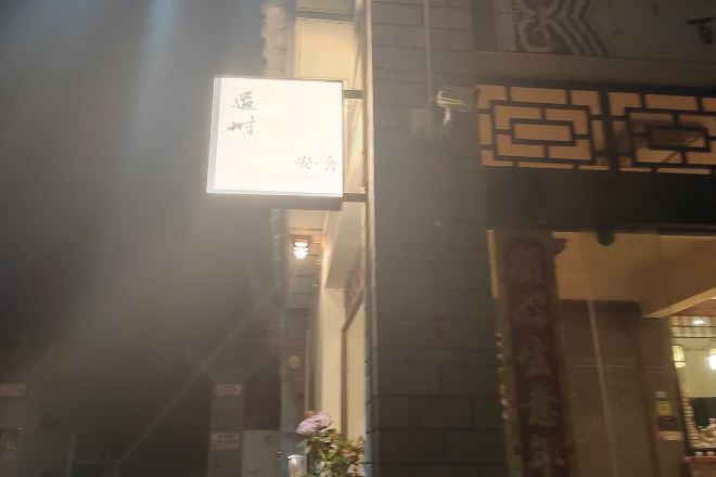 A traditional Chinese architectural entrance with a signboard.