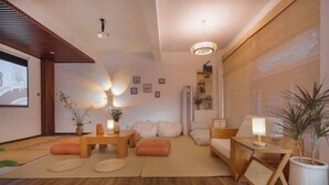 A modern living room with a wooden floor, a sofa set, a coffee table, and a side table with a lamp. - Dali Ancient City Shishi Anshe Vacation Apartment (Dali City)