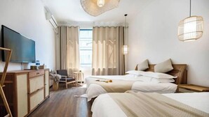 A hotel room with two beds, a TV, a desk, and a chair. - Dali Ancient City Shishi Anshe Vacation Apartment (Dali City)