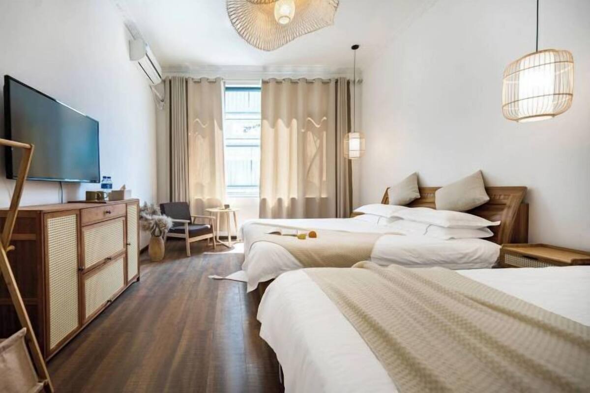 Une chambre d’hôtel avec deux lits, une télévision, un bureau et une chaise.
