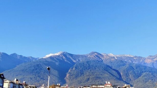 Une ville de montagne avec des bâtiments et un lampadaire.