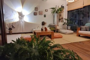 Een moderne woonkamer met een bank, bijzettafeltje en potplanten.