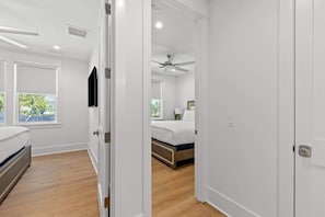 Un dormitorio con cama, ventilador de techo y ventana con persianas.