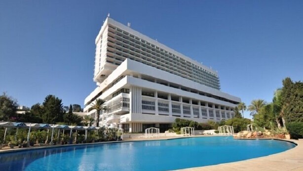 A hotel with a large pool, multiple balconies, and a modern architectural design. - Hotel El Aurassi (Algiers)