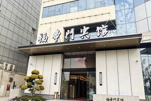 A modern building with a sign that reads '福兴门宾馆'.