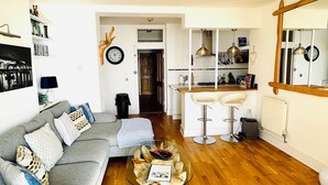 A modern living room with a grey sofa, a glass coffee table, and a wooden floor. - Luxury Seacliff Apartment overlooking Ventnor Beach, Sleeps 4 , Ferry Discounts (Ventnor)