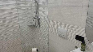 A modern bathroom with a shower, toilet, and vanity. - Anita's mansion (Gattendorf)