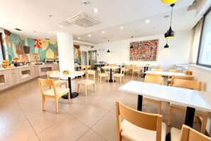 A restaurant with round tables and chairs, a counter with a menu, and a colorful mural on the wall. - HanTing Hotel (Tianjin Hospital Jiefang South Road) (Tianjin)