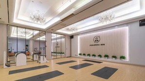 A yoga studio with mirrored walls, a reception desk, and exercise mats on the floor. - Quanzhou City Holiday Hotel (Gucheng Branch) (Quanzhou)