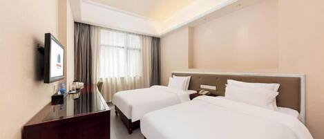 A hotel room with two beds, a desk, a TV, and a window with curtains.