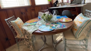 A dining area with a round table, chairs, and a kitchen in the background. - Charming 2-bedroom house in Monroe with AC, WiFi (Monroe)