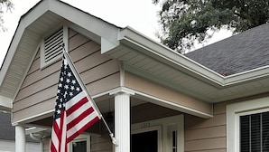 A house with a porch, a flag, and a mailbox. - Charming 2-bedroom house in Monroe with AC, WiFi (Monroe)