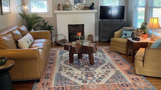 A living room with a fireplace, a ceiling fan, a TV, and a large rug. - Charming 2-bedroom house in Monroe with AC, WiFi (Monroe)