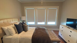 A bedroom with a bed, a TV, a ceiling fan, and a window with blinds. - Charming 2-bedroom house in Monroe with AC, WiFi (Monroe)
