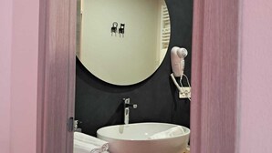 A bathroom with a round mirror, a sink, and a towel rack. - B&B 8380 La Cantina di Piero e 'Netta (Manciano)