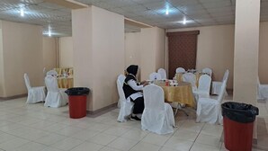 A conference room with round tables, white chairs, and red trash bins. - RAFAHEYAT ALMASHAAER (Makkah)