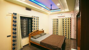 Un dormitorio con cama, cortinas, ventilador de techo y aire acondicionado.